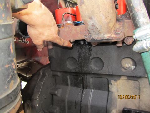 1984 Ford Bronco - A leak is visible on the engine block, with oil dripping into a collection pan below.