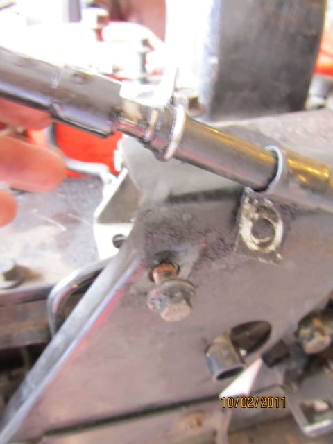 1984 Ford Bronco - A close-up view of a vehicle's mechanical component, showing a bolted bracket and a metal tube.