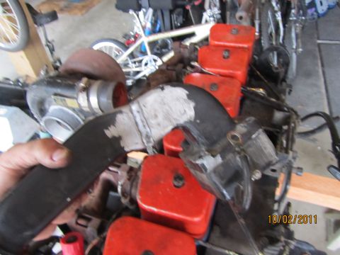 1984 Ford Bronco - Close-up of engine part, possibly a turbocharger and intake manifold assembly.