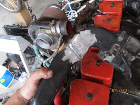 1984 Ford Bronco - A close-up of a turbocharger and exhaust piping, likely for an engine modification project.