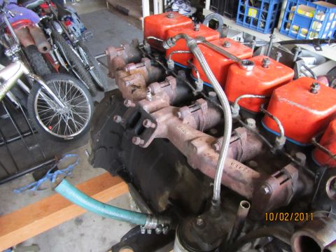 1984 Ford Bronco - Engine components are visible in this close-up shot, with motorcycles in the background.
