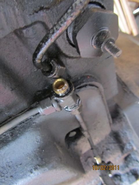 1984 Ford Bronco - A close-up view shows a metal fitting with a brass insert and a braided hose attached, with a date stamp of 10/02/2011 visible.