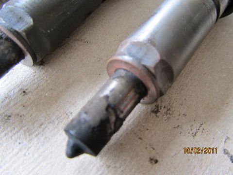 1984 Ford Bronco - Two fuel injectors are shown, with one exhibiting damage to its tip.