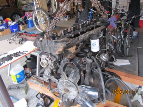1984 Ford Bronco - Engine components are disassembled and suspended for inspection or repair in a garage setting.