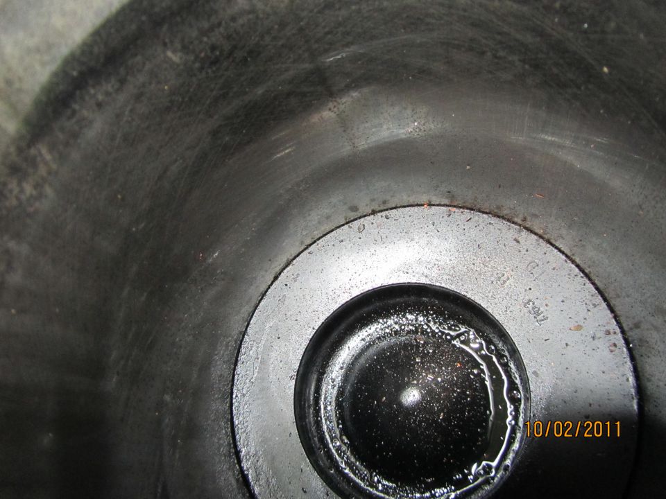 Close-up of an engine cylinder with visible scoring and oil residue. Part number '7N63' is faintly visible