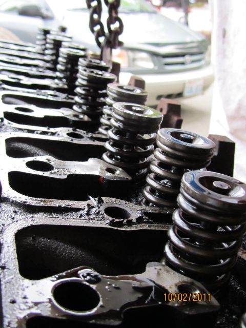 1984 Ford Bronco - Close-up of an engine cylinder head showing valve springs and ports, with a date stamp visible in the lower right corner.