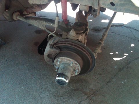 1992 Ford F-150 - Close-up view of a vehicle's front suspension components, including the brake rotor and hub assembly.