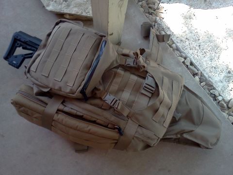 1996 Ford Bronco - Several pieces of tactical gear, including bags and a rifle stock, are arranged on a concrete surface.