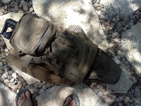 1996 Ford Bronco - A tactical backpack with a rifle stock is placed on a rocky surface.