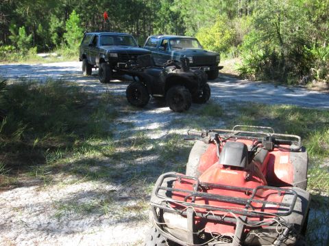 1994 Ford Bronco - A 1994 Ford Bronco is parked on a dirt road with two ATVs in the foreground.