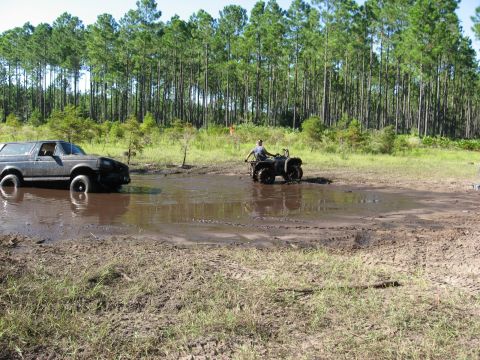 1994 Ford Bronco - A 1994 Ford Bronco is stuck in a mud pit while an ATV rider is nearby.