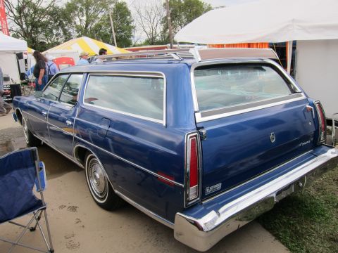 1991 Ford LTD Crown Victoria - Rear view of a blue station wagon, likely from the 1970s, with a roof rack and woodgrain trim.