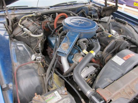 1991 Ford LTD Crown Victoria - The engine bay of a blue vehicle is shown, with various components visible.