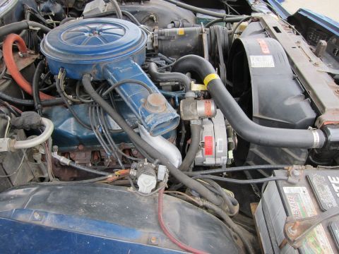 1991 Ford LTD Crown Victoria - Close-up view of a blue engine bay, showing the V8 engine, air cleaner assembly, and battery.