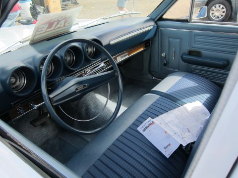 1991 Ford LTD Crown Victoria - The interior of a classic car features blue patterned seats and a dashboard with multiple gauges.