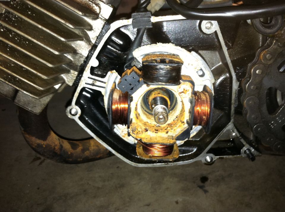 close-up of a rusty motorcycle stator with copper windings
