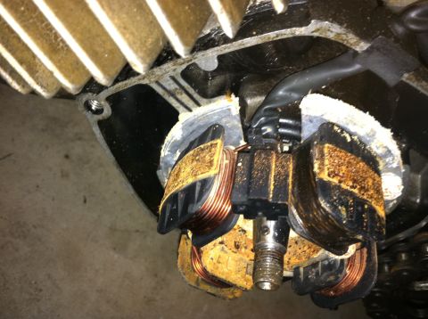 1999 Tomos Targa - Close-up view of a rusty stator and rotor assembly, showing copper windings and mounting hardware.