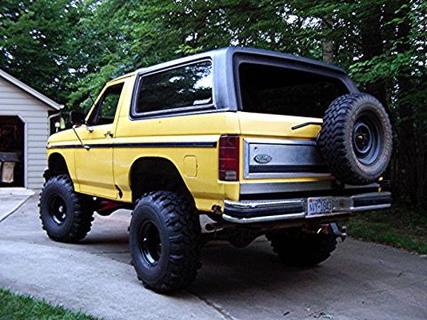 1985 Ford Bronco - This lifted yellow Ford Bronco shows body style cues consistent with the early 1980s, not 1985.