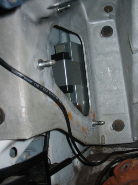 1992 Ford Bronco - A component is mounted within the engine bay, secured by bolts and wires.