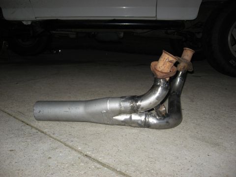 1994 Ford Bronco - Custom exhaust manifold with two pipes merging into one, rusty flanges and visible welds.