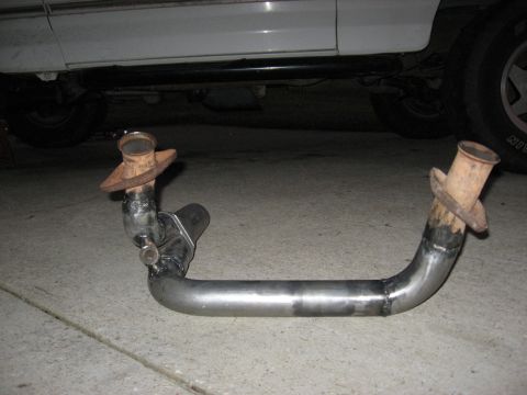 1994 Ford Bronco - Custom exhaust pipe section shown on concrete, with part of a vehicle in the background.