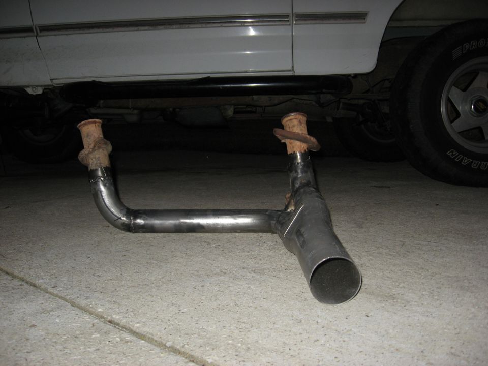 Exhaust pipe assembly removed from a vehicle, showing the muffler and tailpipe sections