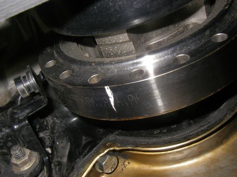 1990 Ford Bronco - Tight close-up of a harmonic balancer installed on the engine, showing the machined timing degree scale stamped into its outer edge with a…