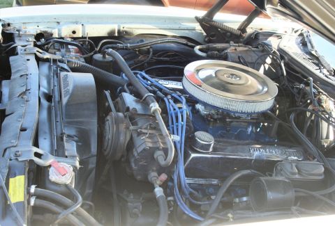 1976 Ford Ranchero - Close-up view of a V8 engine, showing the air filter, carburetor, and spark plug wires.