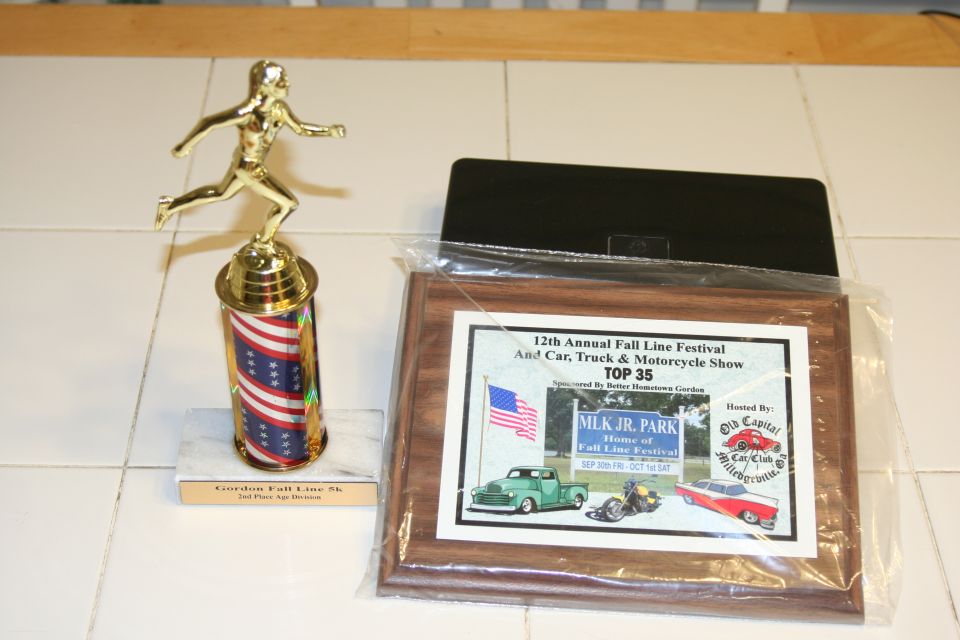Award plaque shows a green truck, motorcycle, and red car