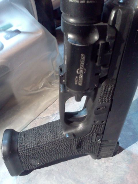 1996 Ford Bronco - Pistol with a mounted tactical light, likely a Glock model.