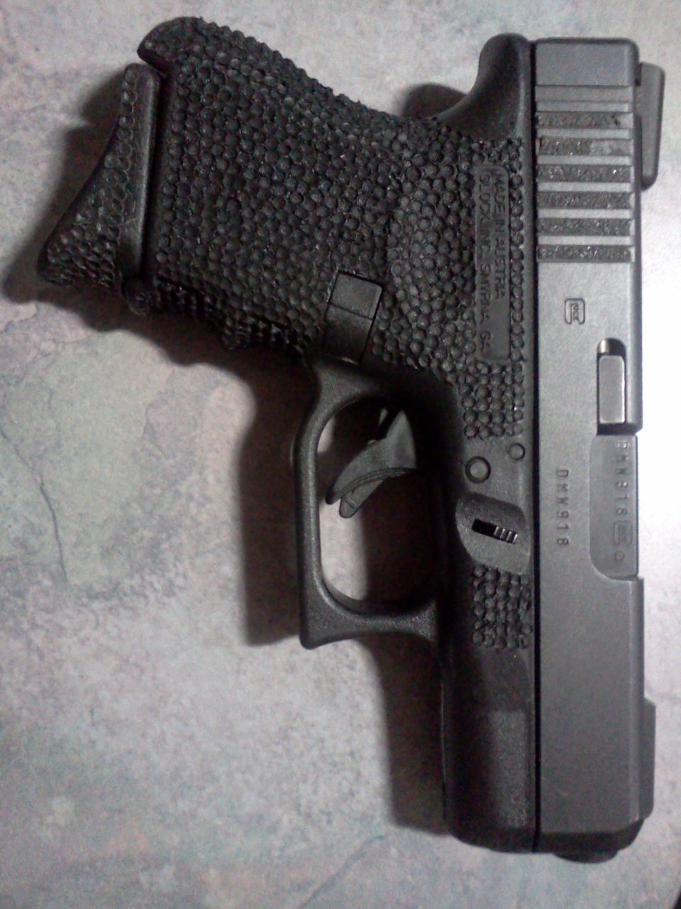 Glock pistol with textured grip and slide markings