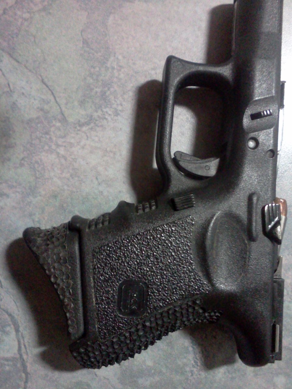 Black Glock pistol grip with textured surface