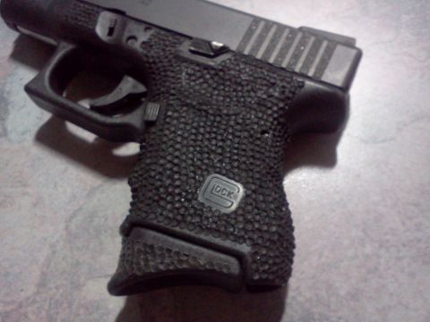 1996 Ford Bronco - A detailed view of a handgun's grip, showing the distinctive texture and brand markings.
