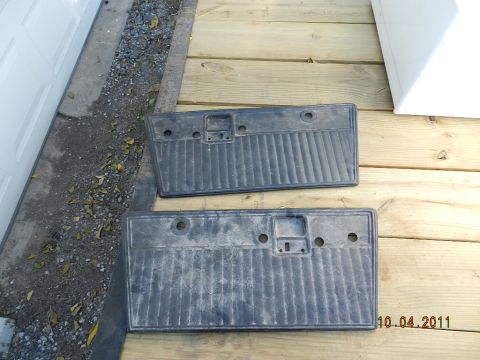 1978 Ford Bronco - Two black door panels are shown resting on a wooden deck next to a garage.