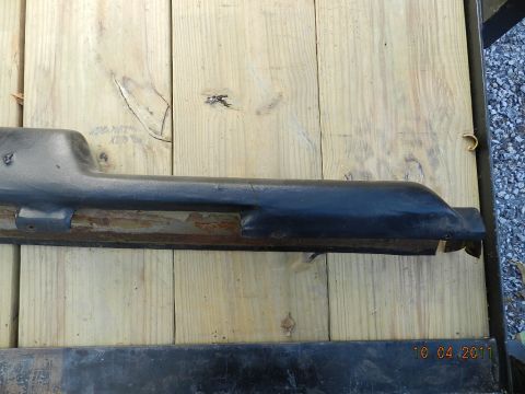1978 Ford Bronco - Close-up of a vehicle's black plastic trim piece, showing wear and rust.