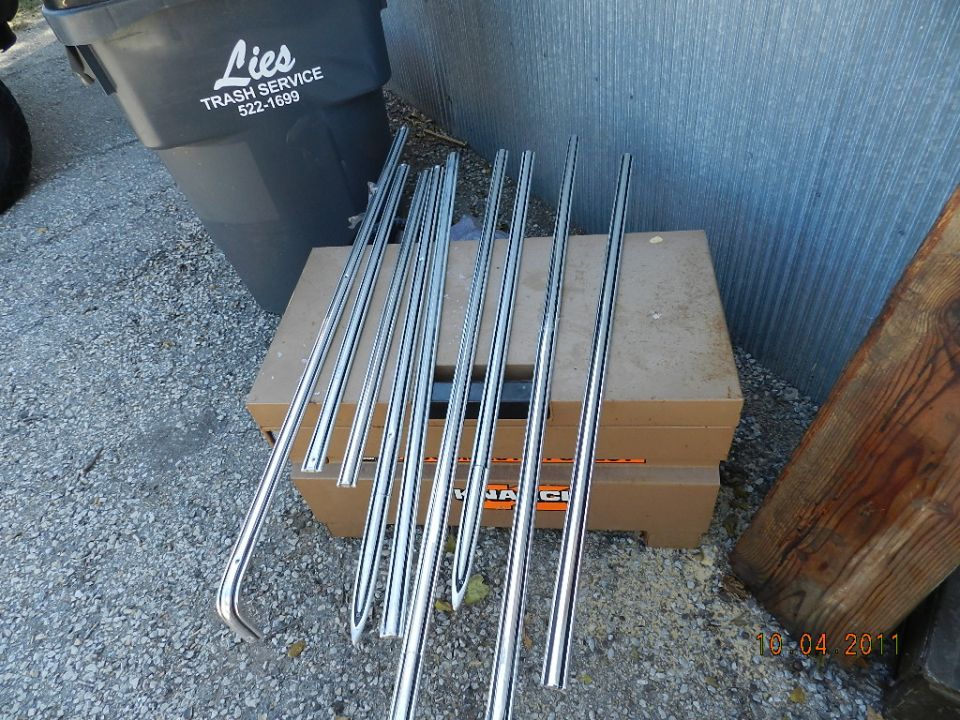 pile of chrome trim pieces on top of cardboard boxes next to a trash can