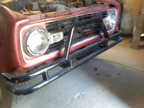 1978 Ford Bronco - The front of a red 1978 Ford Bronco is visible, equipped with a black bull bar and grille.