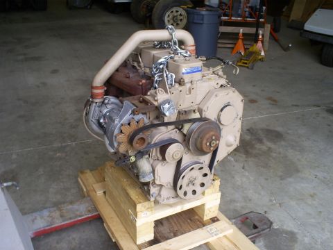 1992 Ford Bronco - Engine assembly with turbocharger and drive belts, mounted on a wooden pallet for transport or storage.