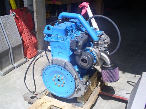 1992 Ford Bronco - A blue engine assembly with a turbocharger and air intake is displayed on a pallet.