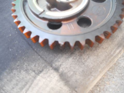 1991 Ford Bronco - A camshaft timing gear is shown, metal construction and orange-coated teeth.
