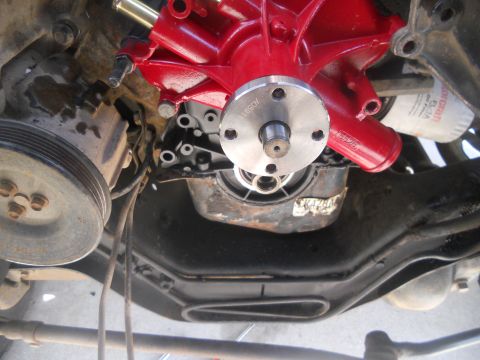 1991 Ford Bronco - Close-up view of a red engine water pump assembly, part of a vehicle's engine system.