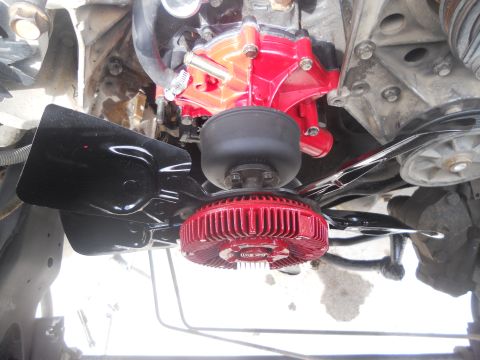 1991 Ford Bronco - Close-up view of engine components including a red water pump and fan clutch.