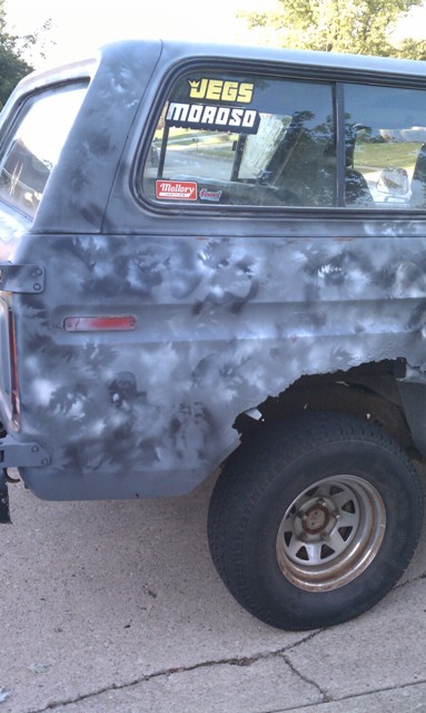 1978 Ford Bronco - Rear quarter panel of a 1978 Ford Bronco shows significant rust damage and aftermarket stickers.