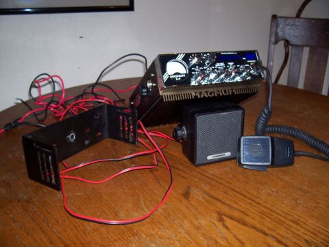 1978 Ford F-150 - A Magnum S-4 CB radio, speaker, and microphone are laid out with their wiring and a mounting bracket on a wooden surface.