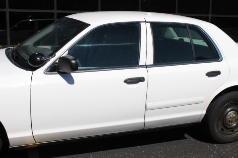 2003 Ford Crown Victoria - This 2003 Ford Crown Victoria sedan is viewed from the side, showing its white exterior and tinted windows.
