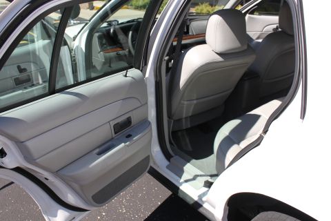 2003 Ford Crown Victoria - Interior view of a white sedan, showing the front and rear seats and door panels.