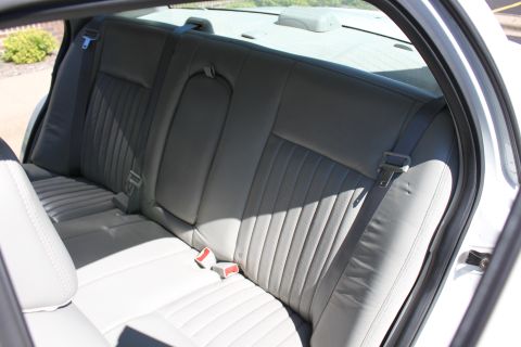 2003 Ford Crown Victoria - Interior view of the rear seating area, showing gray upholstery and seatbelts.
