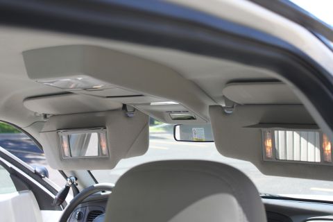 2003 Ford Crown Victoria - Interior view of a car's overhead console and sun visors with illuminated vanity mirrors.