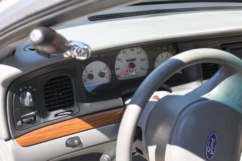 2003 Ford Crown Victoria - The instrument cluster and dashboard details of a 2003 Ford Crown Victoria are visible in this interior shot.