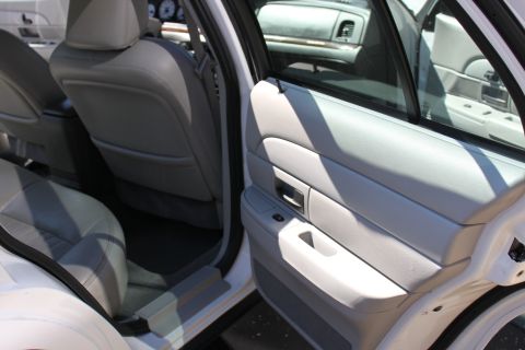 2003 Ford Crown Victoria - Interior view of a white 2003 Ford Crown Victoria, highlighting the gray leather seats and door panel.